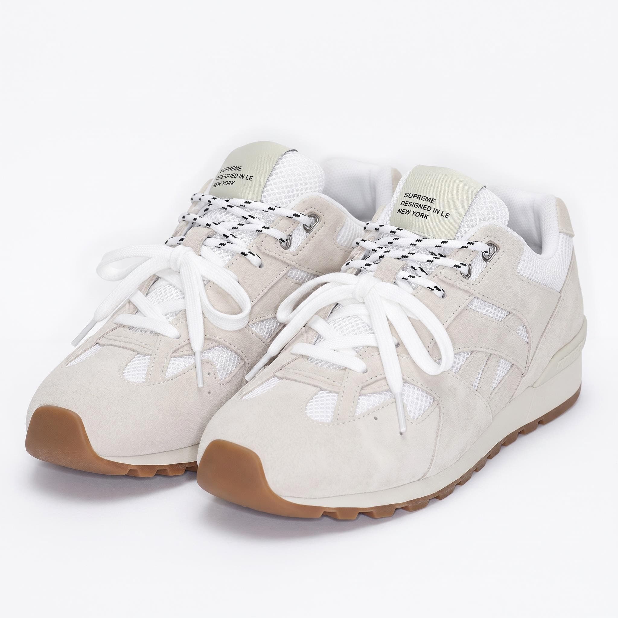 AI packshot of a pair of off-white suede and mesh sneakers on a white background